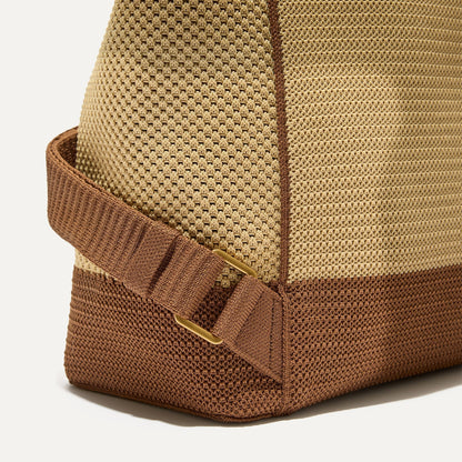 A close up of the The Cinch Backpack in Brown Butter focusing on the gold hardware on the straps.