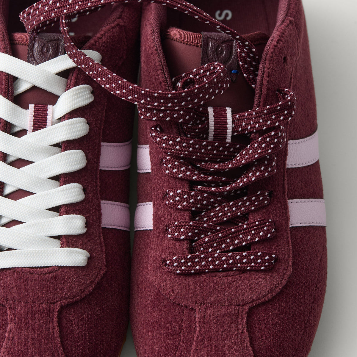 Overlay:: Extra pair of laces included—swap for a new look anytime. | Alt:: Close up of the top of The Ivy Sneaker in ReVelvet Syrah, showing different lace choices.